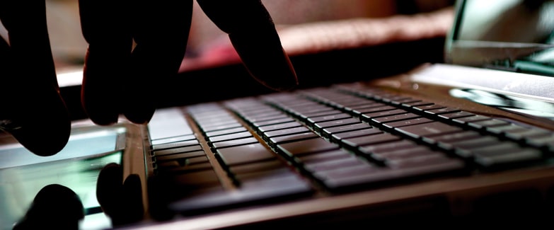 Image of Hand Typing on Laptop Keyboard