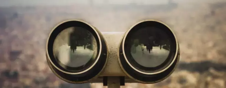 Binoculars at a viewpoint overlooking a city