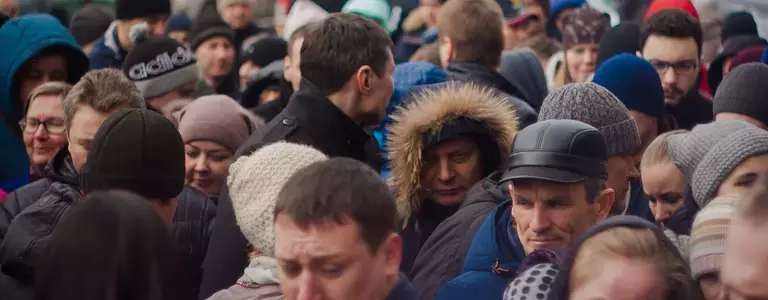 Crowd of people walking on a sidewalk in winter