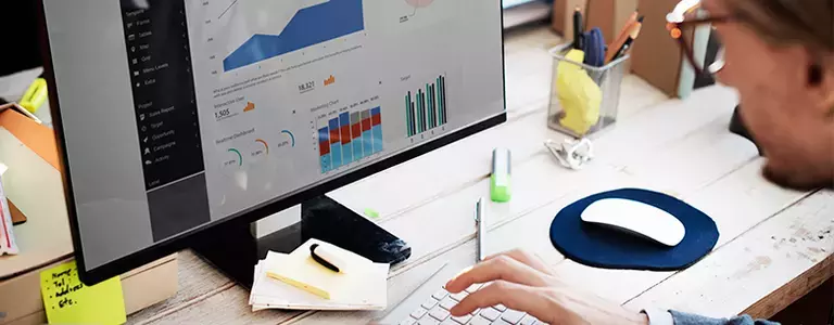 Employee looking at various charts on a computer screen