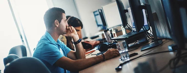 Man looking at his computer screen in an open plan office