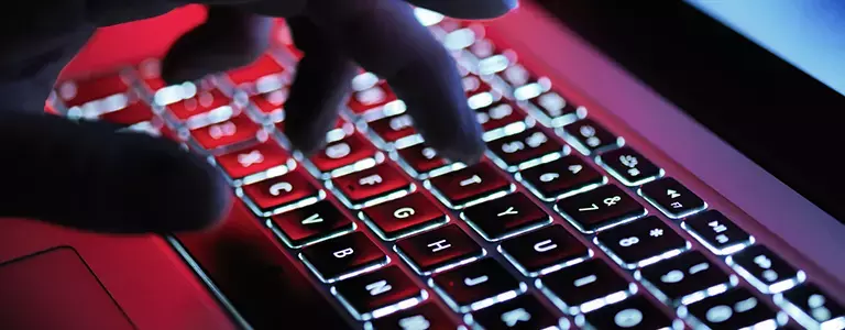Closeup of a hand typing at a laptop