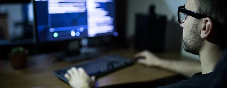 Man with glasses coding at a home office