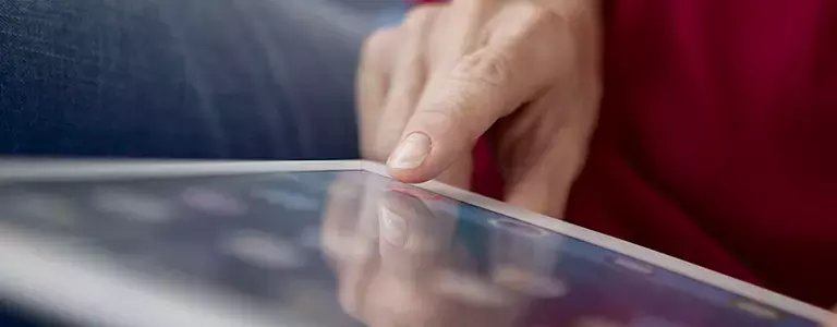 Zoomed in on a finger tapping a tablet touchscreen