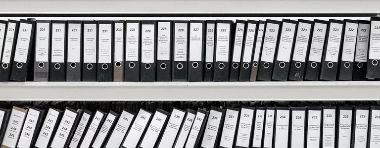 Dozens of numbered binders on a shelf