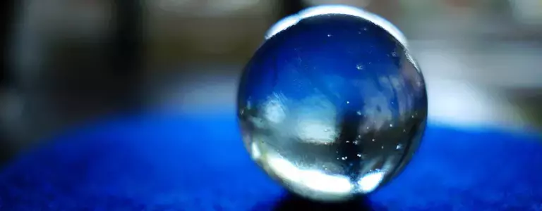 Closeup of a glass marble resting on blue felt