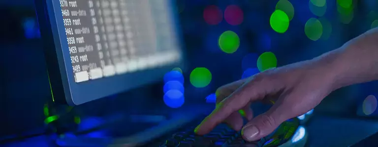 Person typing in a dark server room