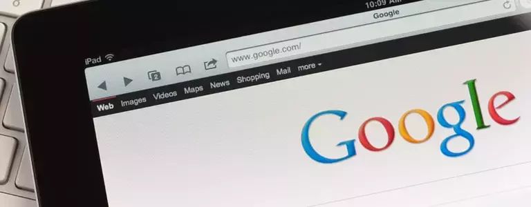 Closeup of a laptop displaying the Google home screen