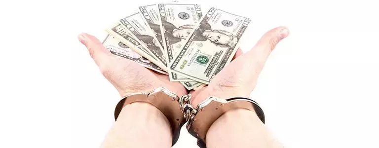 Handcuffed person holding out cash