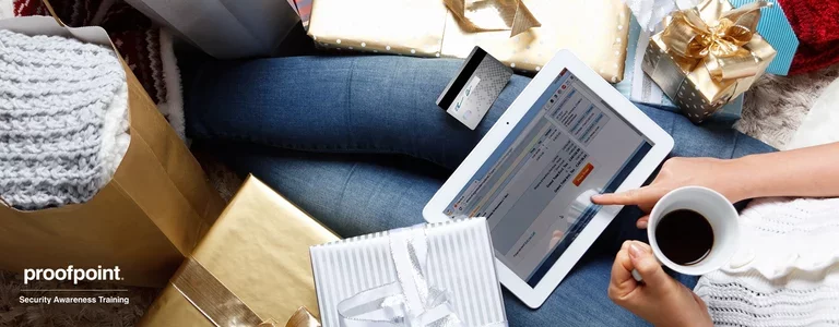 Woman sitting among gift wrapped packages using her card on her tablet