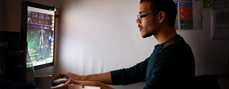 Man playing a video game at his home computer