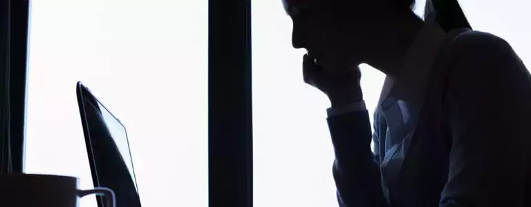 Silhouette of a woman using a computer