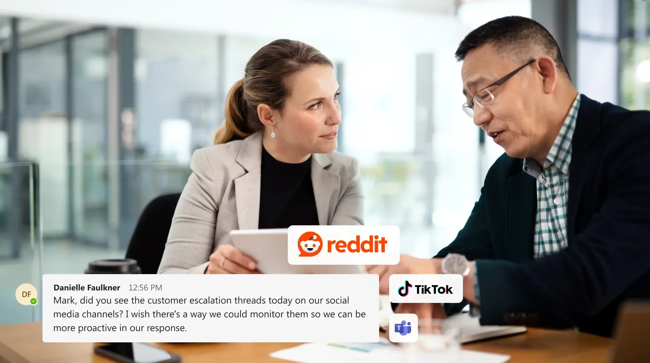 Two colleagues looking at a tablet with social media logos, discussing data governance security